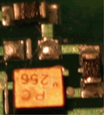 《圖一　置於印刷電路板的SAW濾波器，旁邊有多個0402電阻器  》