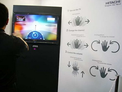 《图十一 Hitachi展示只要在影像传感器前挥舞手，就可以切换电视频道、调整电视机音量的技术。》