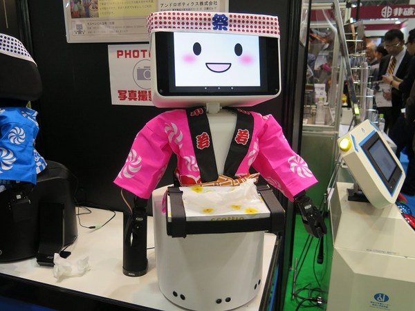 图5 : 在日本去年12月iREX展出的服务型机器人Mosupenkun，可以协助店家发放试用品、市场调查、聊天等功能。