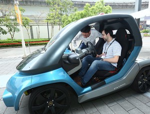 國外買主於戶外展區自動駕駛車試乘活動實際體驗具自動駕駛功能的電動車。