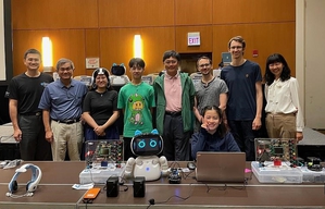 台灣團隊與德國團隊於美國IEEE CEC 2023國際會議合影。國際電機電子工程師學會專家Tom Compton在會場佩戴腦波帽體驗無人機控制。
