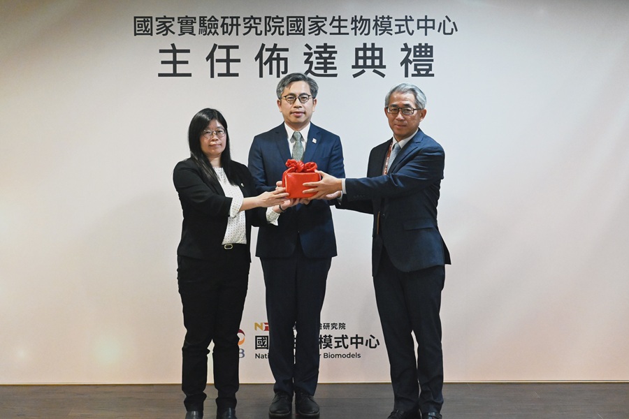 由國研院院長蔡宏營 (中)監交，生物模式中心前主任秦咸靜 (左)將印信交給新任主任張芳嘉 (右)。