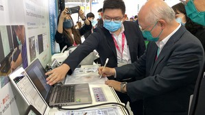 圖為筑波醫電業務經理吳尚昆(左)與高雄市政府衛生局局長黃志中(右)體驗手寫系統。