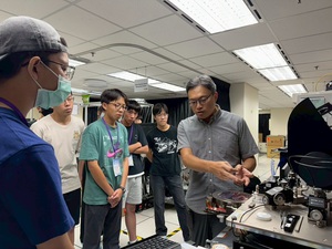 高中生半导体科普营学员实际走访国研院半导体中心新竹基地的晶圆制程实验设施，听取晶片量测解说，图二为学员叁访无尘室黄光区。